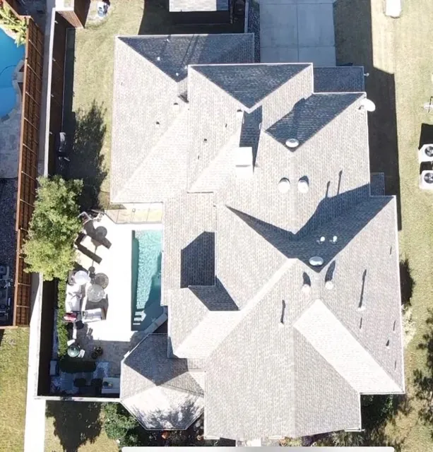 aerial view of a completed light shingle roof and pool